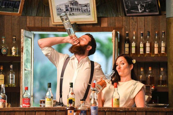 Fun couple photoshoot at the bar where man is drinking directly from bottle