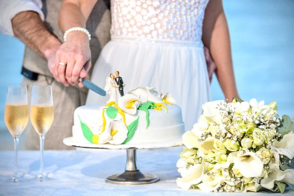 wedding cake cutting with champagne and flowers 
