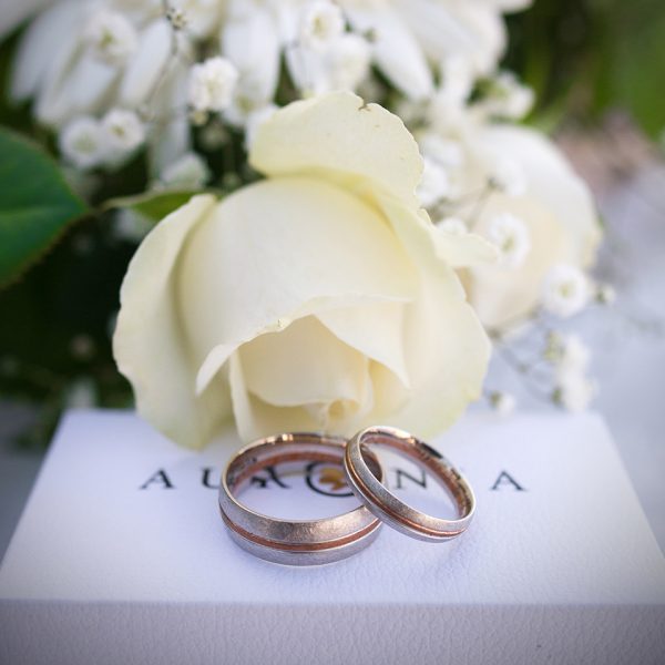 nice wedding rings on a branded box with floral behind