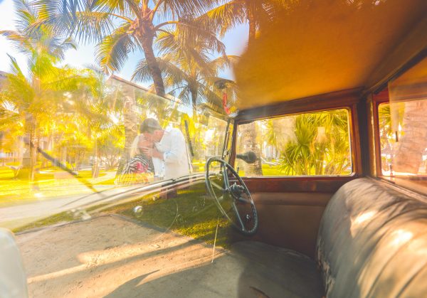 Point of view of a couple kissing through the windshield of vintage car 