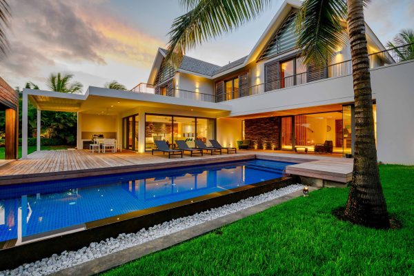 real estate house with immense blue pool and big garden with coconut trees