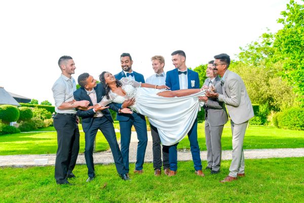 The bride is posing with groomsman