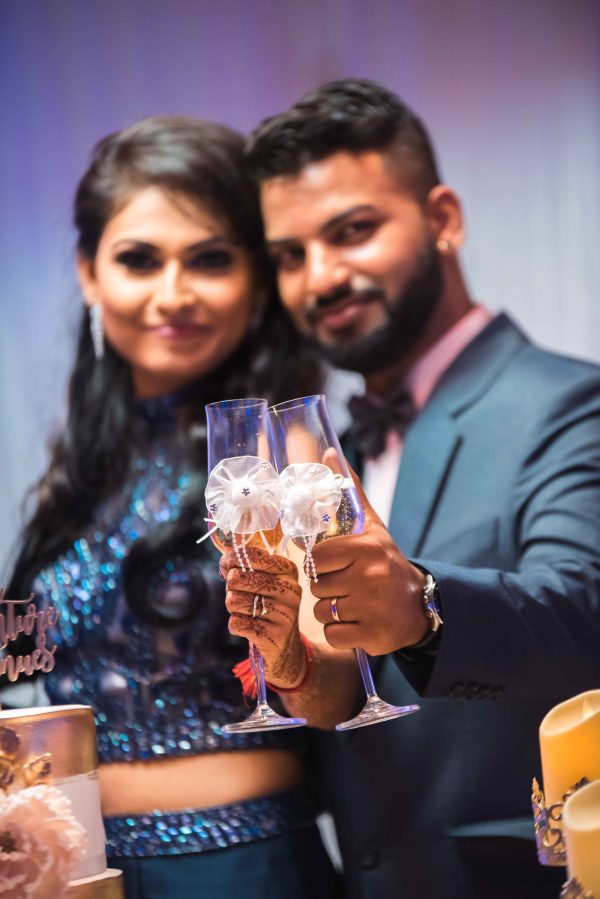 couple posing with champagne glasses during wedding reception 