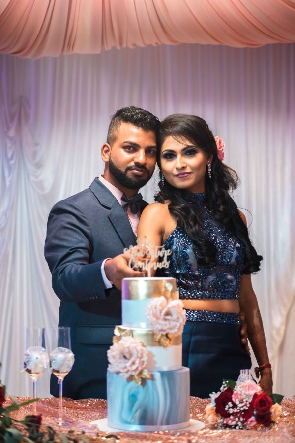 Couple posing with wedding cake 