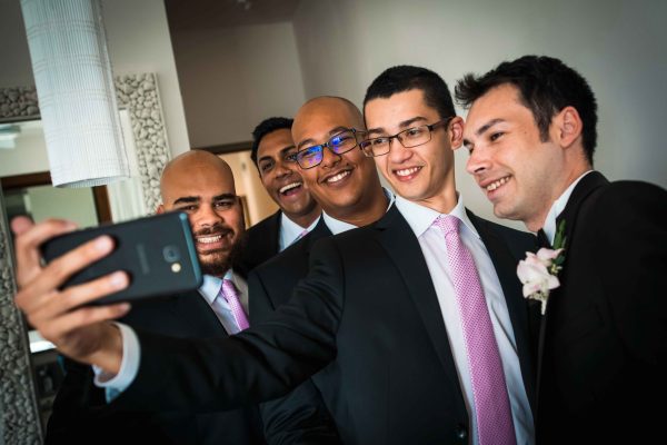 Groom is taking a selfie with groomsmen 